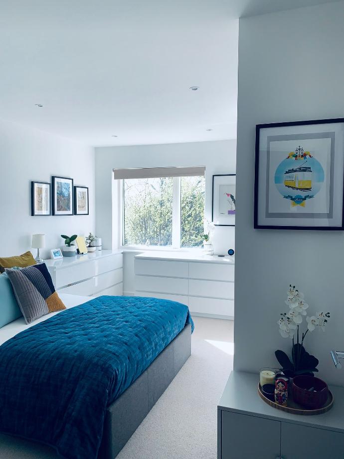 blue bed linen near white wooden framed glass window